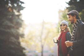 Couple in woods with coffee in Fall