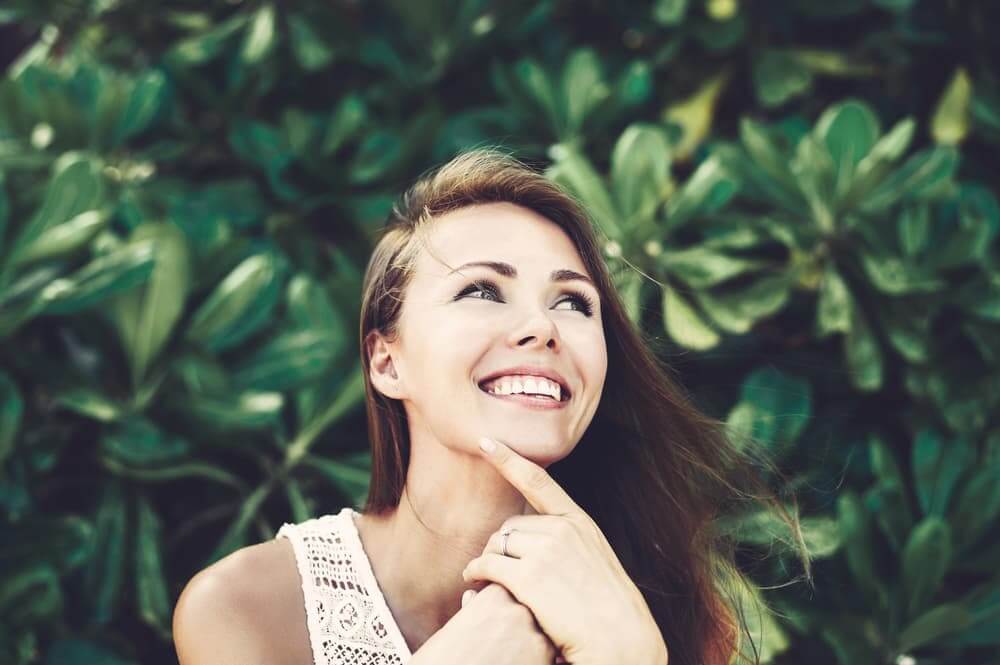 Happy woman in front of leaves