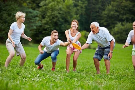 Family playing frisbee in park