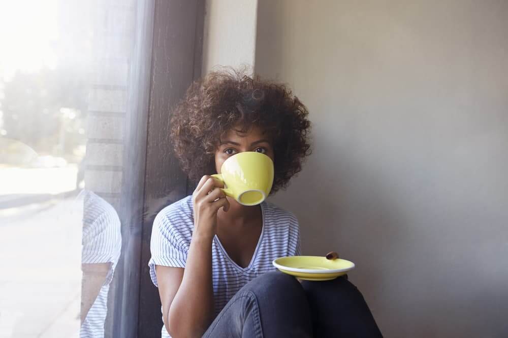 Woman sipping from mug and saucer